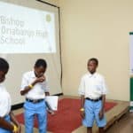 3 school children standing together doing a presentation