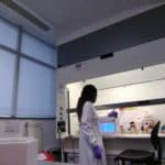 scientist testing an equipment in front of a fume hood