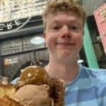 A picture of Ollie with a large cone of ice-cream in an ice-cream shop