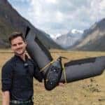 Dr Olly Bartlett holding a drone in a mountainous wetland.