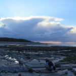 Sitting on a beach collecting rocks at sun set