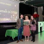 Two women and one man holding a certificate