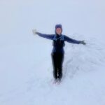 Person in waterproof jacket and trousers on a snowy hillside with no view