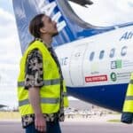 Oleg Kozhura next to the FAAM Airborne Laboratory’s atmospheric research aircraft. The aircraft is blue and white, with big text "FAAM" on the tail. You can also see cloud probes mounted on a wing