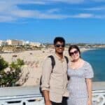 Man and woman standing at a viewpoint above a beach
