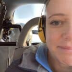 Close up of a womanm wearing ear defenders sat on a helicopter