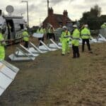 People in high-vis laying out metal barriers