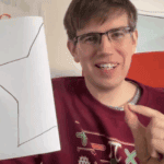 Christian Lawson-Perfect holding a folded piece of paper with half a star visible.