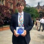 Christian Lawson-Perfect in a suit, holding an award.